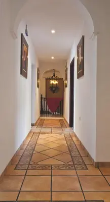 a hallway with a tile floor and white walls at Hotel Restaurante El Duque in Medina Sidonia