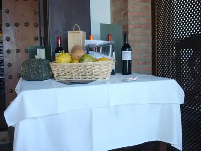 a basket of fruit and a bottle of wine on a table at Hotel Restaurante El Duque in Medina Sidonia
