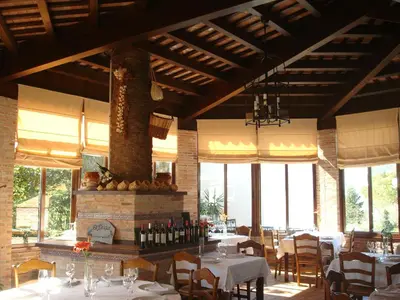 a restaurant with white tables and chairs and windows at Hotel Restaurante El Duque in Medina Sidonia