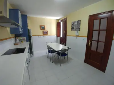 a kitchen with a table and chairs in it at Dúplex centro, climatizado, garaje, piscina, WIFI in Sanlúcar de Barrameda