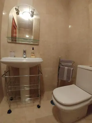 a bathroom with a sink and a toilet and a mirror at Dúplex centro, climatizado, garaje, piscina, WIFI in Sanlúcar de Barrameda