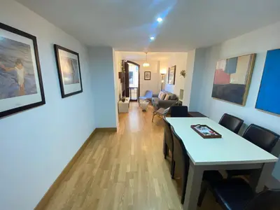 a living room with a table and a couch at Dúplex centro, climatizado, garaje, piscina, WIFI in Sanlúcar de Barrameda