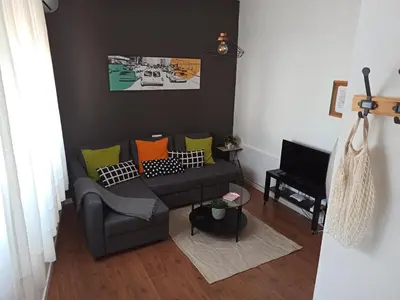 a living room with a couch and a television at Atico SIROCO in Sanlúcar de Barrameda