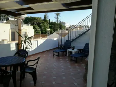 a balcony with chairs and tables and a staircase at Atico SIROCO in Sanlúcar de Barrameda