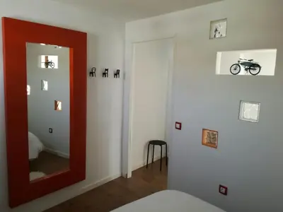 a room with a mirror and a room with a motorcycle on the wall at Atico SIROCO in Sanlúcar de Barrameda