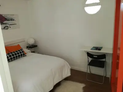 a bedroom with a bed and a desk with a chair at Atico SIROCO in Sanlúcar de Barrameda