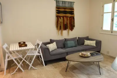 a living room with a couch and a table and chairs at Apartamento El Balneario in Cádiz