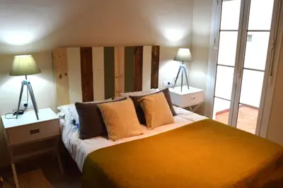 a bedroom with a large bed with two lamps at Apartamento El Balneario in Cádiz