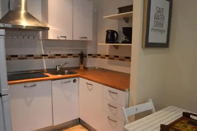 a small kitchen with white cabinets and a sink at Apartamento El Balneario in Cádiz