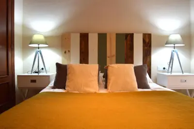 a bedroom with a large bed with two lamps at Apartamento El Balneario in Cádiz