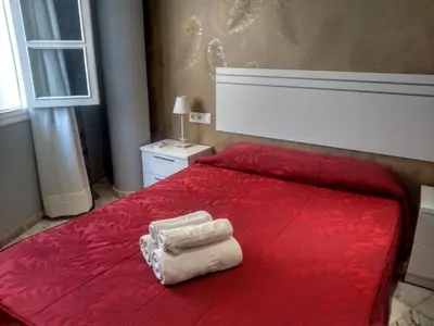 a red bed with two towels on top of it at Apartamentos El Vestuario in Cádiz