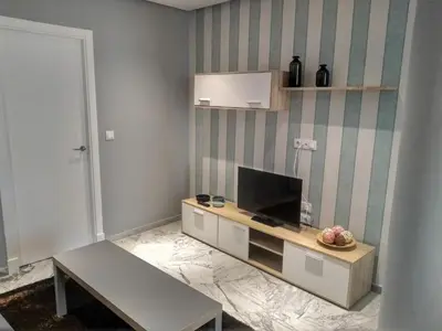 a table with a blue bottle and glasses on it at Apartamentos El Vestuario in Cádiz