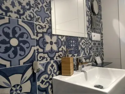 a bathroom with blue and white tiles on a wall at Apartamentos El Vestuario in Cádiz