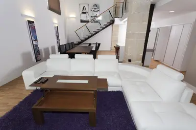 a living room with a white couch and a table at Dúplex tipo Loft - Parking opcional in Jerez de la Frontera