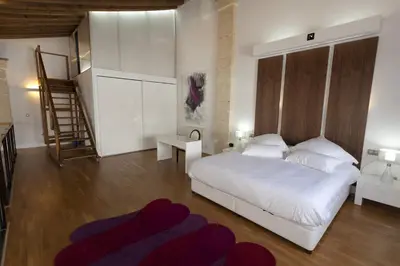 a bedroom with a white bed and a staircase at Dúplex tipo Loft - Parking opcional in Jerez de la Frontera