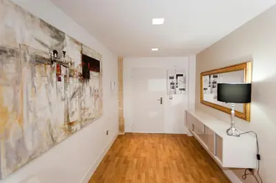 a hallway with white walls and a tv on a wall at Dúplex tipo Loft - Parking opcional in Jerez de la Frontera