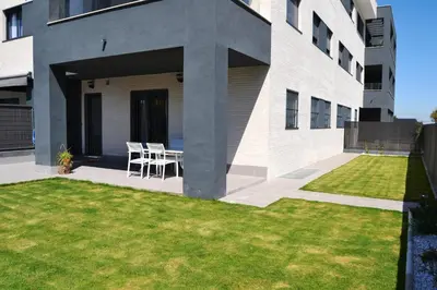 a house with a patio and a grass yard at Residencial Costa Doñana (Sanlucar de Barrameda) in Sanlúcar de Barrameda