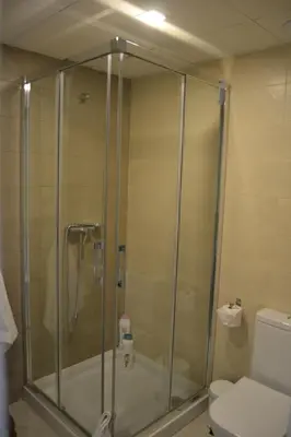 a shower stall in a bathroom with a toilet at Residencial Costa Doñana (Sanlucar de Barrameda) in Sanlúcar de Barrameda