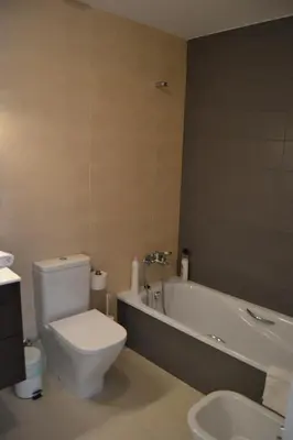 a bathroom with a toilet and a tub and a sink at Residencial Costa Doñana (Sanlucar de Barrameda) in Sanlúcar de Barrameda
