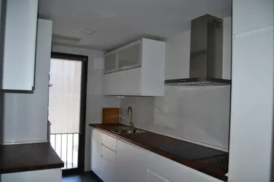 a kitchen with white cabinets and a sink at Residencial Costa Doñana (Sanlucar de Barrameda) in Sanlúcar de Barrameda