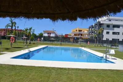 a swimming pool in the middle of a park at Residencial Costa Doñana (Sanlucar de Barrameda) in Sanlúcar de Barrameda