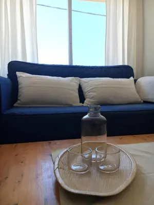 two glasses on a plate on a table with a blue couch at Casa Algaida in Sanlúcar de Barrameda