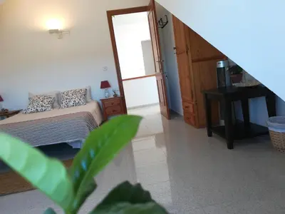 a living room with a bed and a stair case at Casa Algaida in Sanlúcar de Barrameda