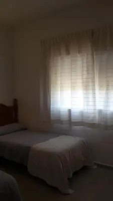 a bedroom with two beds in front of a window at Casa Algaida in Sanlúcar de Barrameda