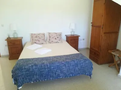 a bedroom with a bed with a blue and white blanket at Casa Algaida in Sanlúcar de Barrameda