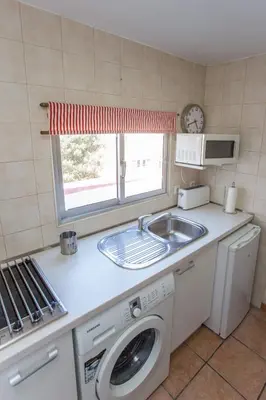 a kitchen with a sink and a washing machine at Casa Jerez Alameda del Banco in Jerez de la Frontera