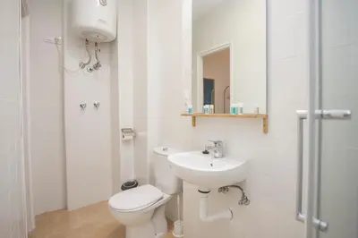 a white bathroom with a toilet and a sink at Casa Jerez Alameda del Banco in Jerez de la Frontera