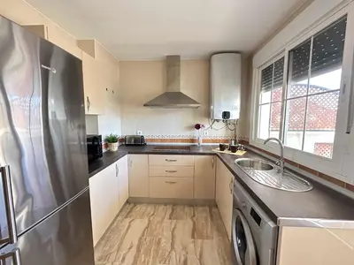 a kitchen with a stainless steel refrigerator and a sink at Taymar in Chiclana de la Frontera