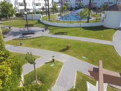 a view of a park with a swimming pool at Taymar in Chiclana de la Frontera