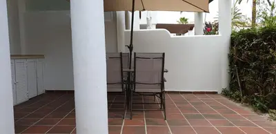 two chairs and an umbrella on a patio at Taymar in Chiclana de la Frontera