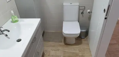 a bathroom with a white toilet and a sink at Taymar in Chiclana de la Frontera