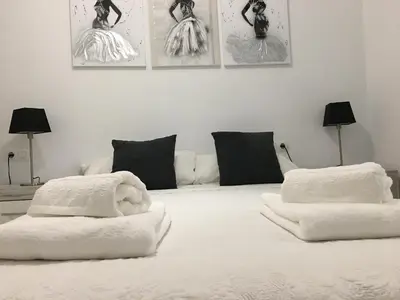 a white bed with two white towels on it at Casa de Corralón in Cádiz