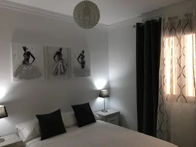 a bedroom with a bed with three pictures on the wall at Casa de Corralón in Cádiz