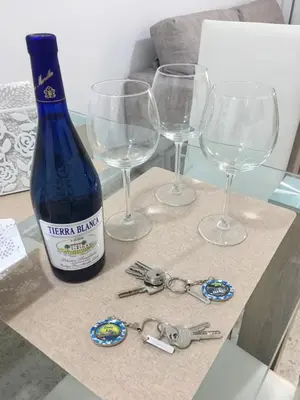 a bottle of wine and three wine glasses on a table at Casa de Corralón in Cádiz