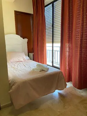 a bedroom with a bed and a large window at Hotel Medina Centro in Jerez de la Frontera