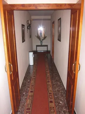 a hallway with a long red carpet in a room at Hotel Restaurante El Lago in Arcos de la Frontera