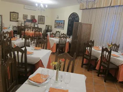 a restaurant with tables and chairs with white tablecloths at Hotel Restaurante El Lago in Arcos de la Frontera