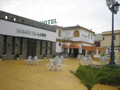 a group of white chairs in front of a building at Hotel Restaurante El Lago in Arcos de la Frontera
