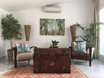 a room with two chairs and an old trunk at CASA PALACIO en Jerez de la Frontera con piscina privada in Jerez de la Frontera