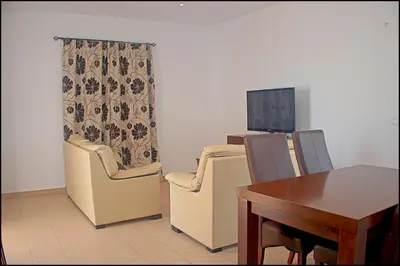 a living room with two chairs and a table and a television at Chalet Ruperto in Conil de la Frontera