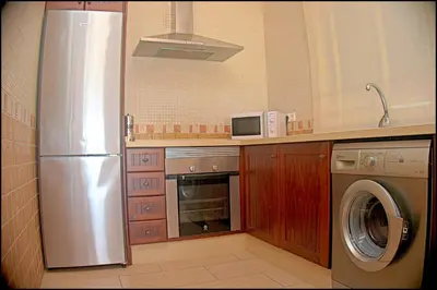 a kitchen with a stainless steel refrigerator and a washer at Chalet Ruperto in Conil de la Frontera