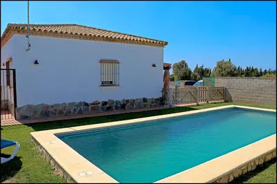a swimming pool in front of a house at Chalet Ruperto in Conil de la Frontera