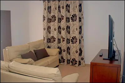 a living room with a couch and a television at Chalet Ruperto in Conil de la Frontera