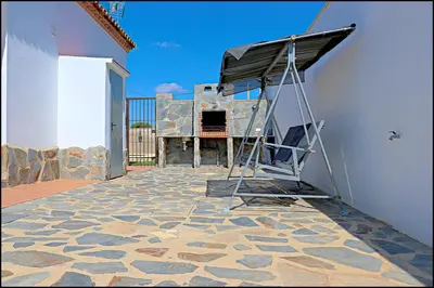 a ladder on the side of a building with a grill at Chalet Ruperto in Conil de la Frontera