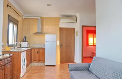 a kitchen with a refrigerator and a couch in a room at Casa El Cortijillo in Conil de la Frontera
