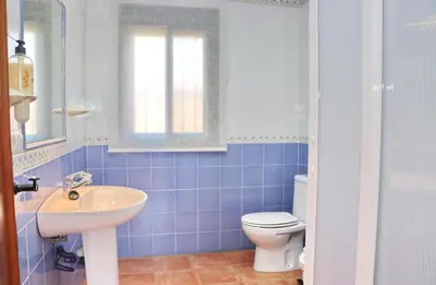 a blue tiled bathroom with a sink and a toilet at Casa El Cortijillo in Conil de la Frontera